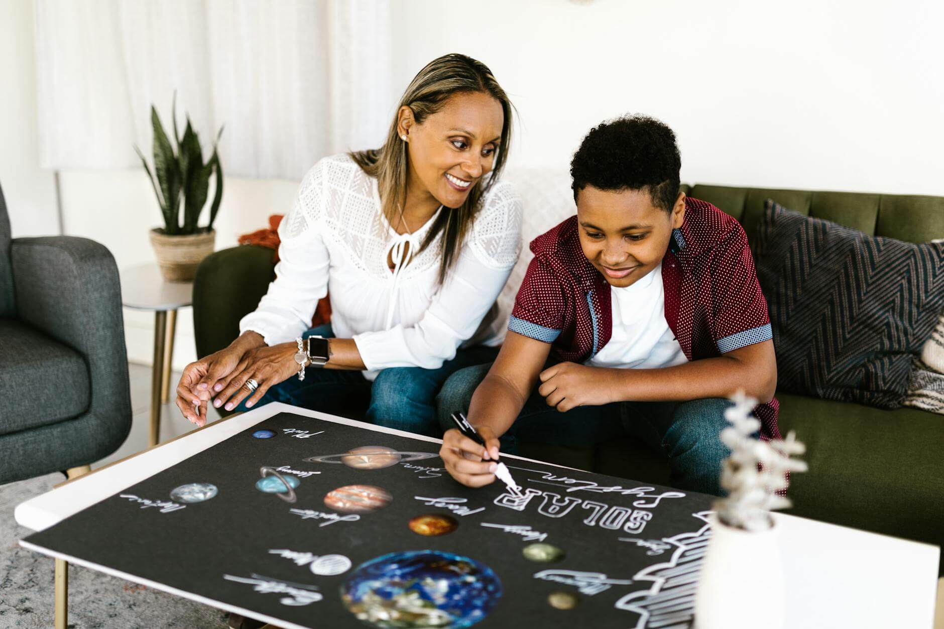 a young boy making poster at home with happy parent. Enter the #CreateWithCB event today.